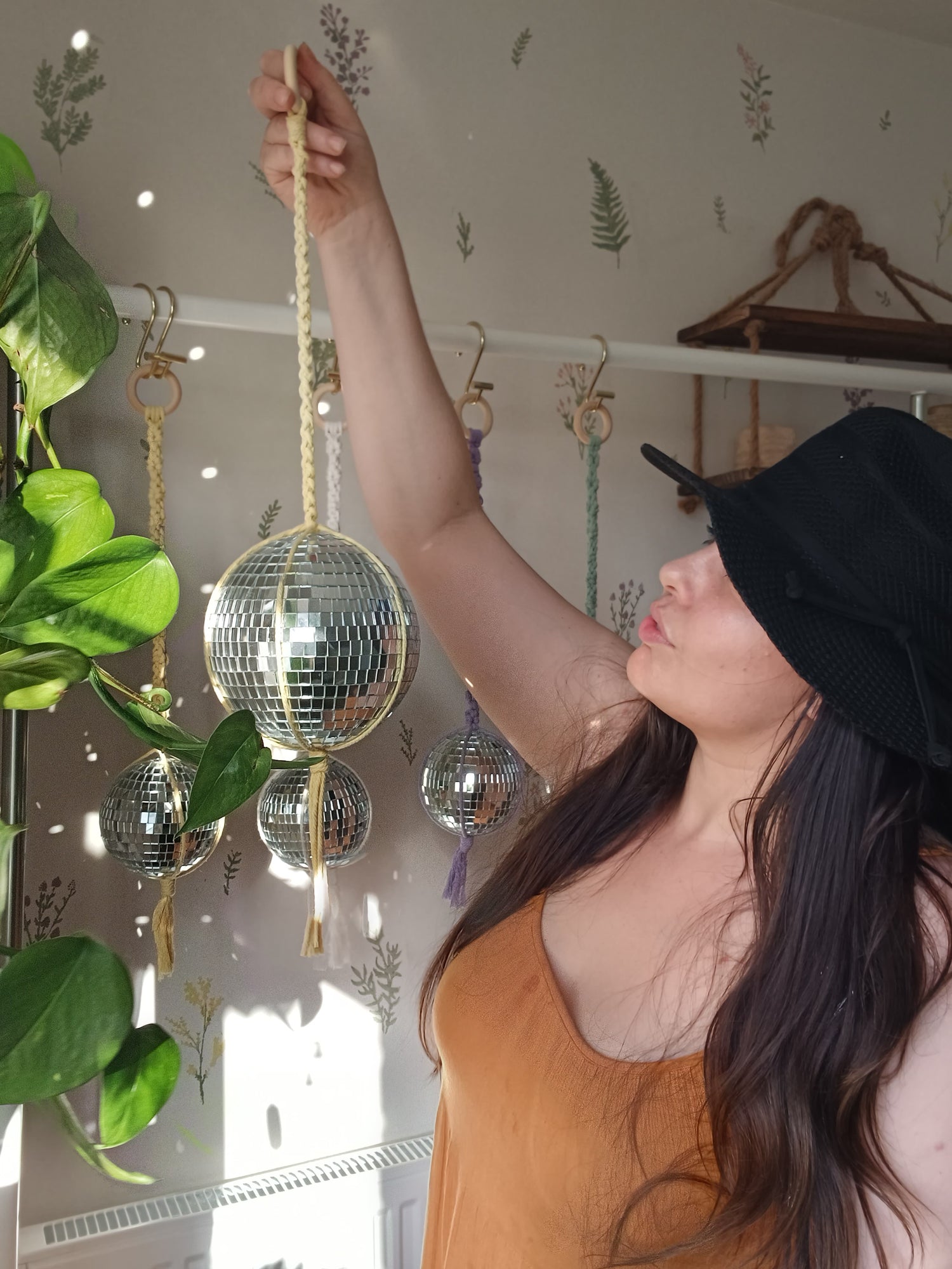 Woman holding macrame disco ball hanger