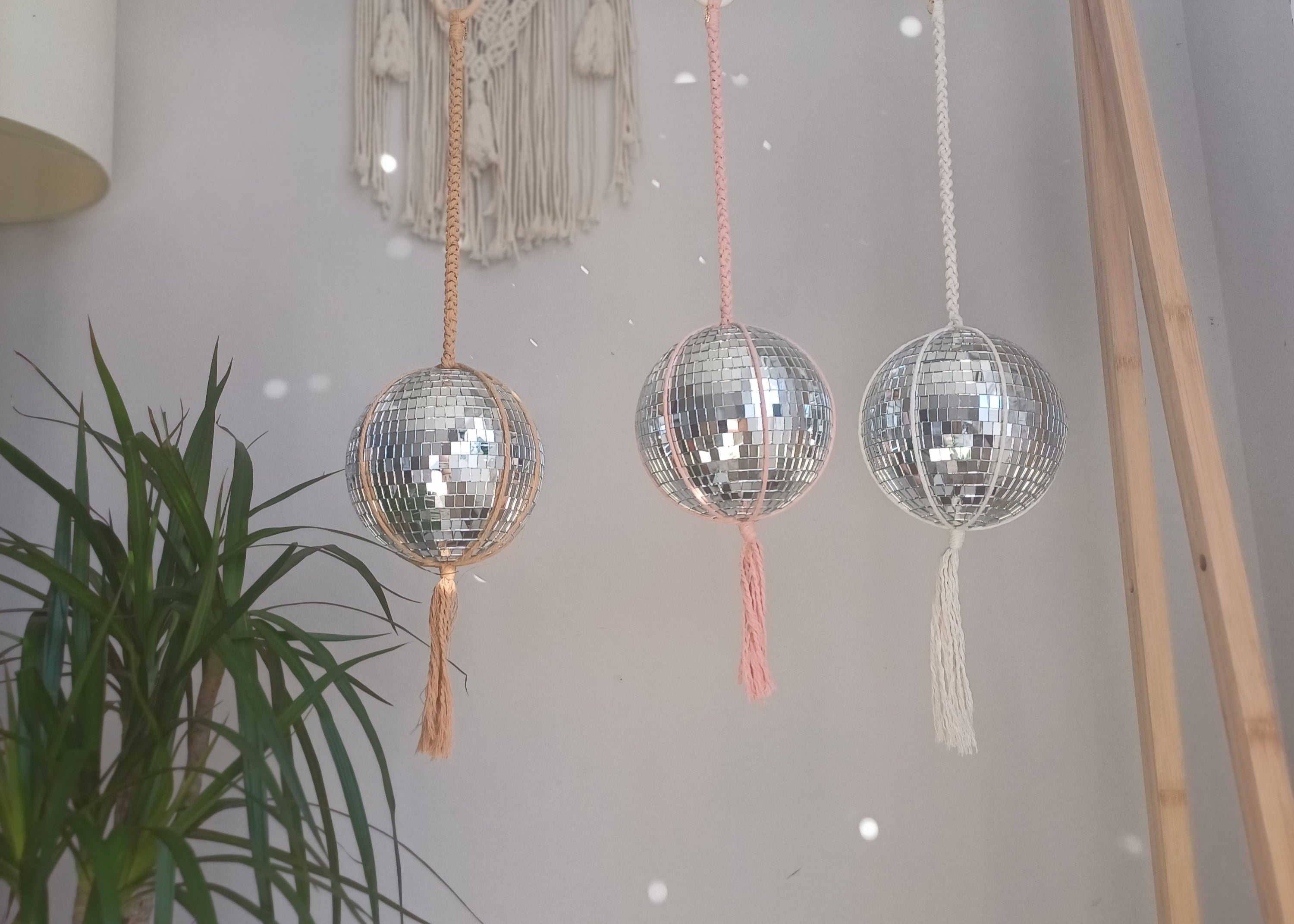 3 disco ball macrame hangers with a macrame tapestry hanging on wall